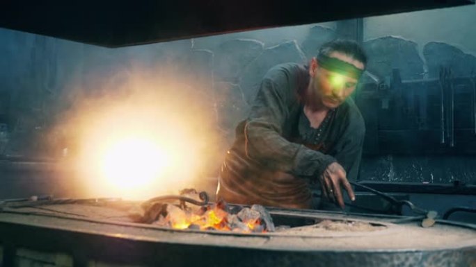 一个铁匠用钳子在火中加热金属刀。