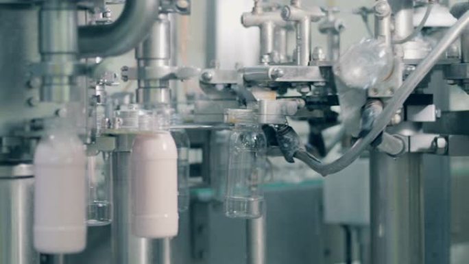 食品工厂的自动化生产线。在工厂用酸奶填充瓶子的过程。