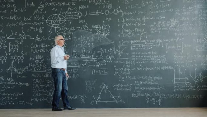 成人科学家在课堂上行走的黑板上写公式的时间流逝