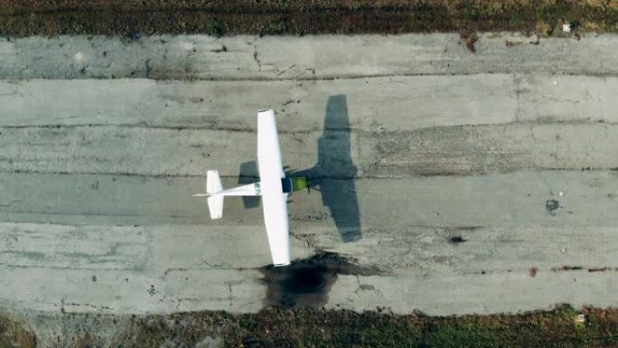 破旧的跑道上有一架小型喷气式飞机在俯视图中