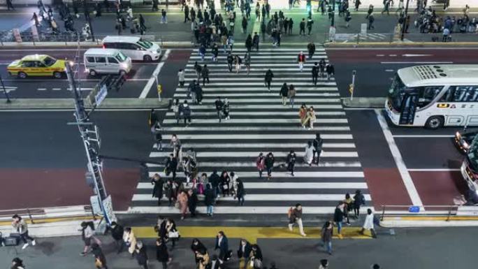 在日本新宿东京市，夜间，人群不确定的人在街上与汽车交通交叉路口行走的4k时间流逝。日本文化与购物街概