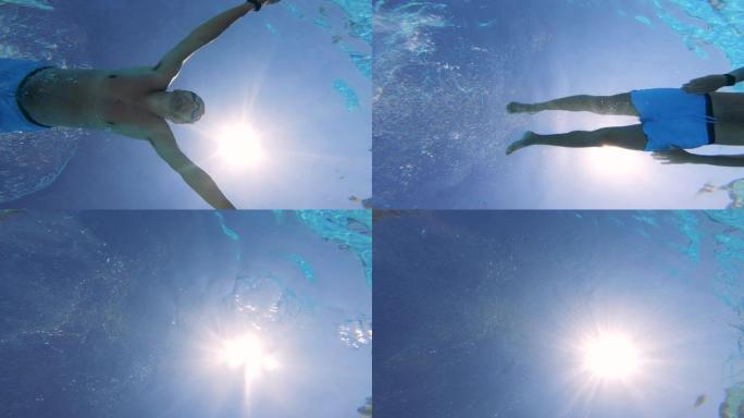 一名男子正对着太阳在水下游泳蛙泳