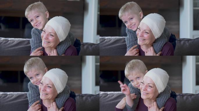 一位从癌症中康复的祖母与她的孙子在沙发上依sn。