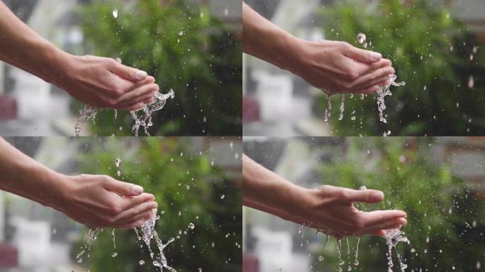 一个孩子的特写镜头把他的手放在雨中，你会看到滴在他的手上弹跳。