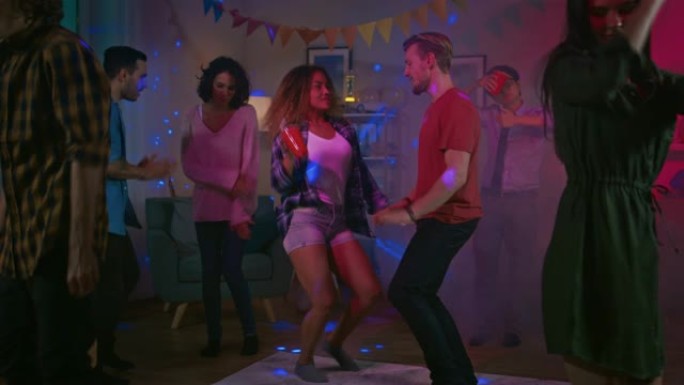 在大学之家聚会上: 一群不同的朋友玩得开心，跳舞和社交。男孩和女孩在客厅里跳舞。迪斯科霓虹灯频闪灯照