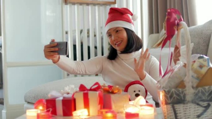 年轻女子在圣诞节用手机和礼品盒庆祝