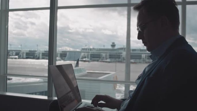 体贴的商人在机场使用笔记本电脑