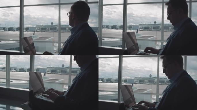 体贴的商人在机场使用笔记本电脑
