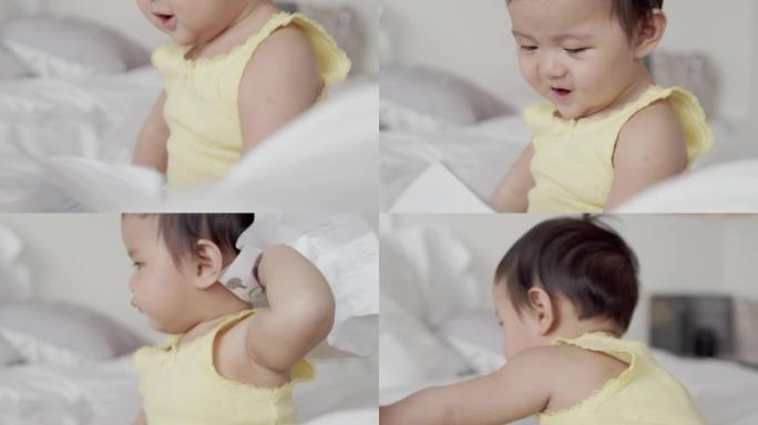 亚洲8个月女婴喜欢在家在白色床上玩耍。