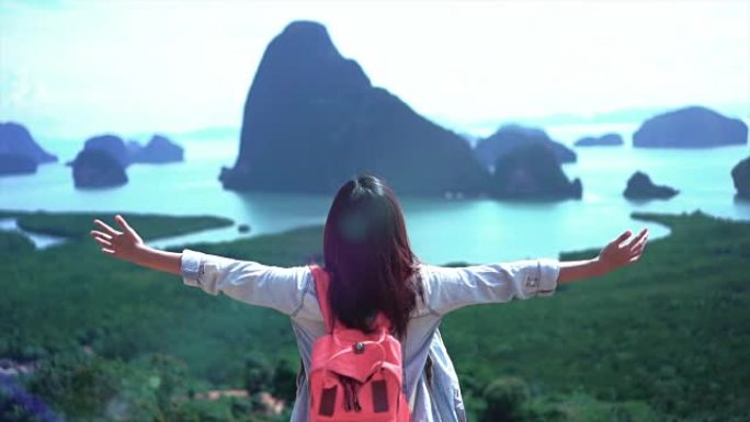 迷人的亚洲女性旅行者的4k慢动作镜头在山顶上举起手臂，在Samed Nang Chee观看风景，感受