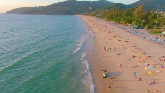 卡隆海滩日落，人们在海中游泳，享受日光浴，度假海滩。由于检疫新型冠状病毒肺炎，在关闭海滩前几天。空中