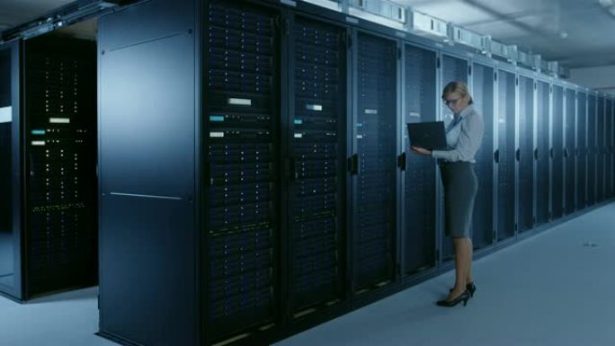 在数据中心: 女it技术人员在笔记本电脑上运行维护程序，控制操作服务器机架的最佳功能。现代高科技电信
