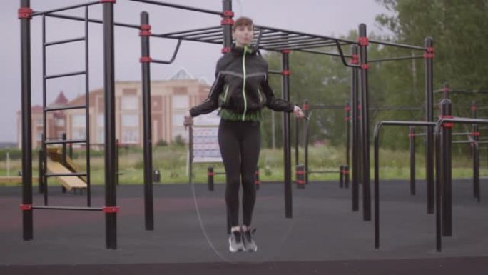 运动女子在户外健身场所跳绳