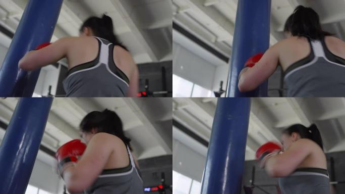 女拳击手在健身房进行重包锻炼
