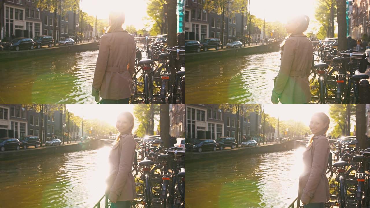 阿姆斯特丹阳光明媚的日子，女人站在运河旁，对着镜头微笑