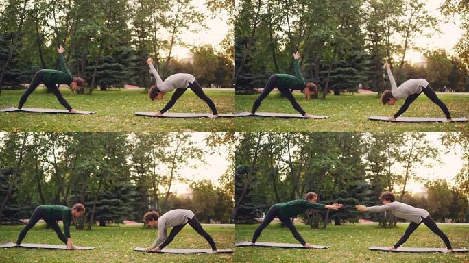 瑜伽学生正在户外锻炼，教练在城市公园的绿色和黄色草地上的垫子上伸展双腿，向后弯曲。