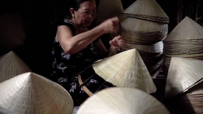 越南坎托省Ap Thoi Phuoc村老传统房子里制作传统越南帽子的4k镜头弱光场景，传统艺术家概念
