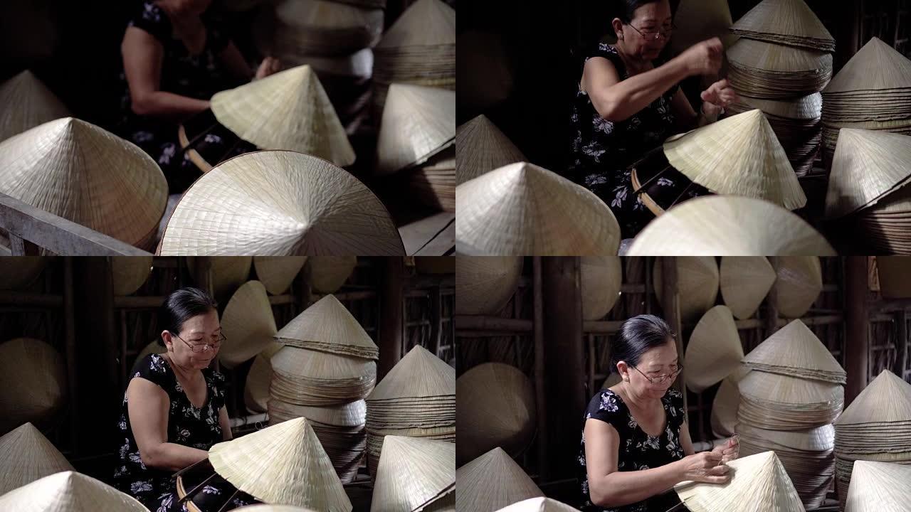 越南坎托省Ap Thoi Phuoc村老传统房子里制作传统越南帽子的4k镜头弱光场景，传统艺术家概念