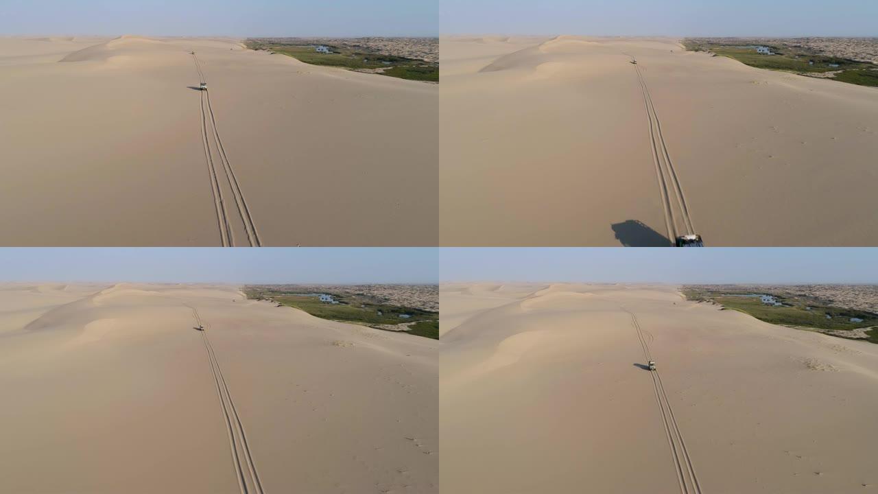 参观纳米比亚骷髅海岸纳米布沙漠的绿洲之泉后，游客沿着沙丘行驶的4k空中变焦