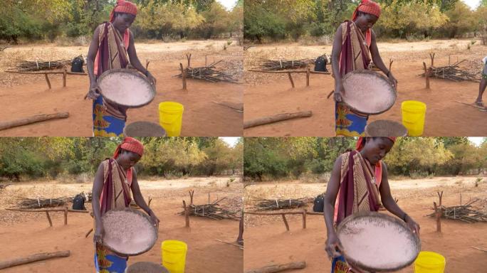 一名妇女用一种古老的传统方法筛选高粱，津巴布韦
