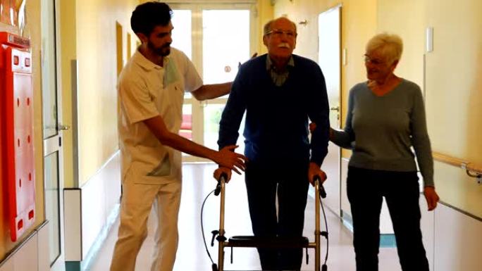 男子与妻子和护士在康复中心进行步行锻炼