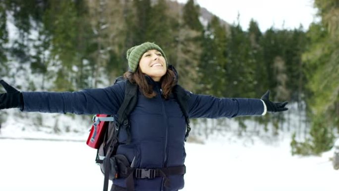 在山里，一个女孩在树林里呼吸着清新的空气。自由和开放的空间，冥想和放松的地方。