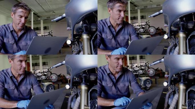 在摩托车维修车库使用笔记本电脑的男性机械师4k