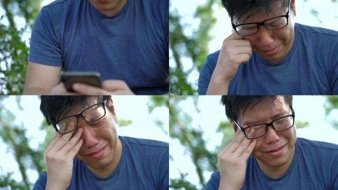 悲伤的亚洲男子在手机上阅读坏消息