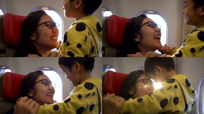 快乐的亚洲母亲和儿子在飞机上。