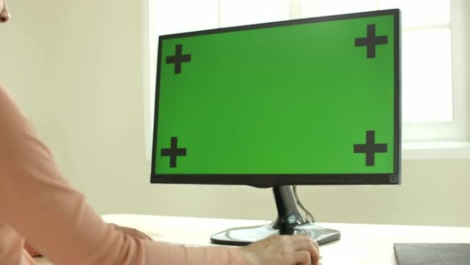 女人使用带有绿屏的计算机，多莉射击跟踪
