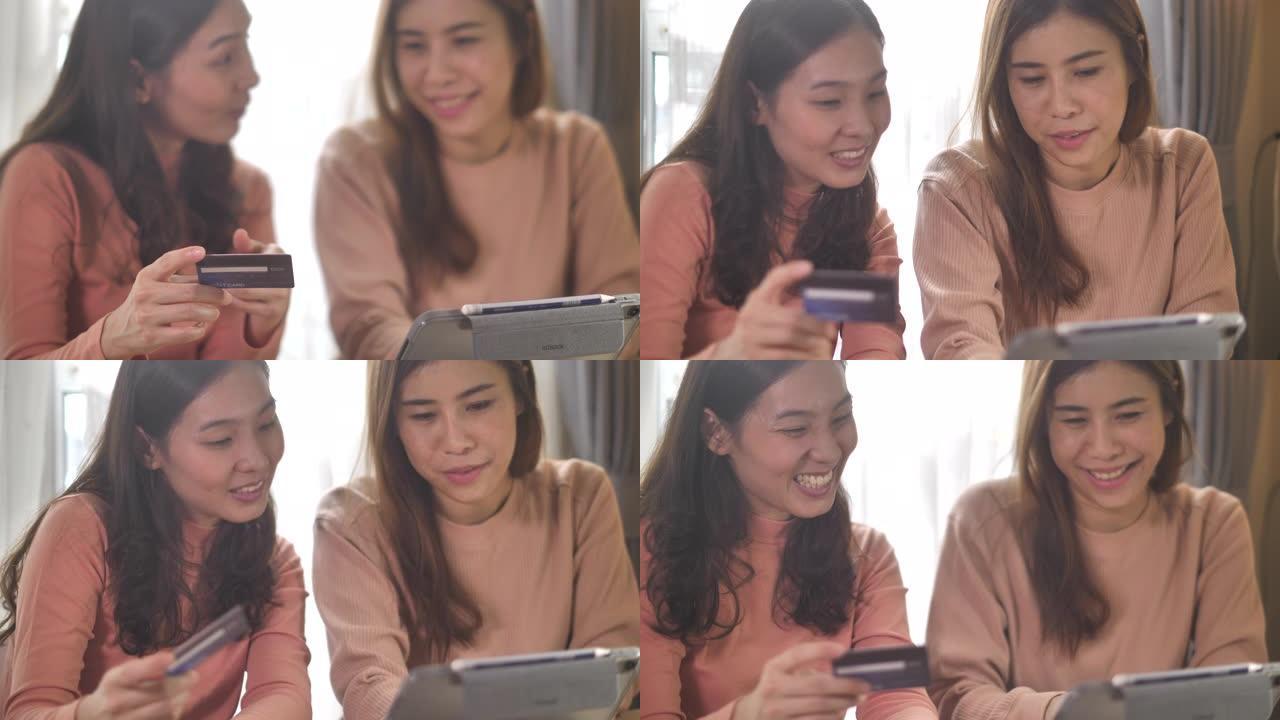 两名亚洲妇女在家中使用数字平板电脑在线购物