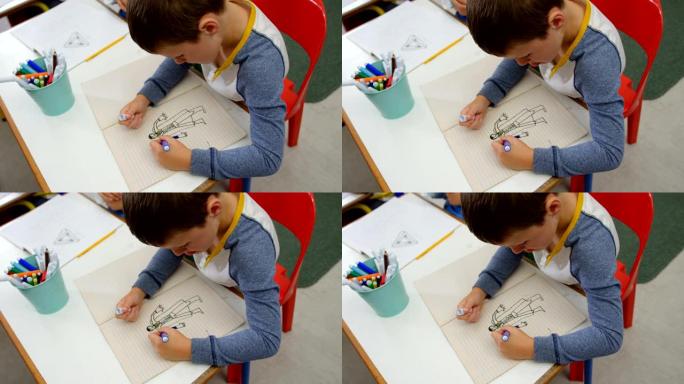 白人男生在教室4k笔记本上绘画的高角度视图