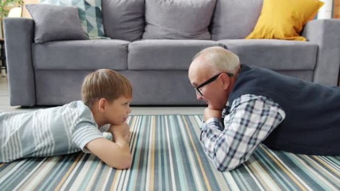 祖父与好奇的孩子交谈，分享在房屋地板上放松的经验