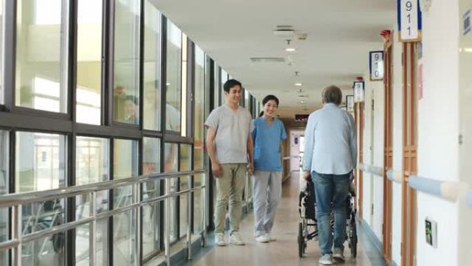 年轻的亚洲医疗保健专业人员在走廊上问候高级患者