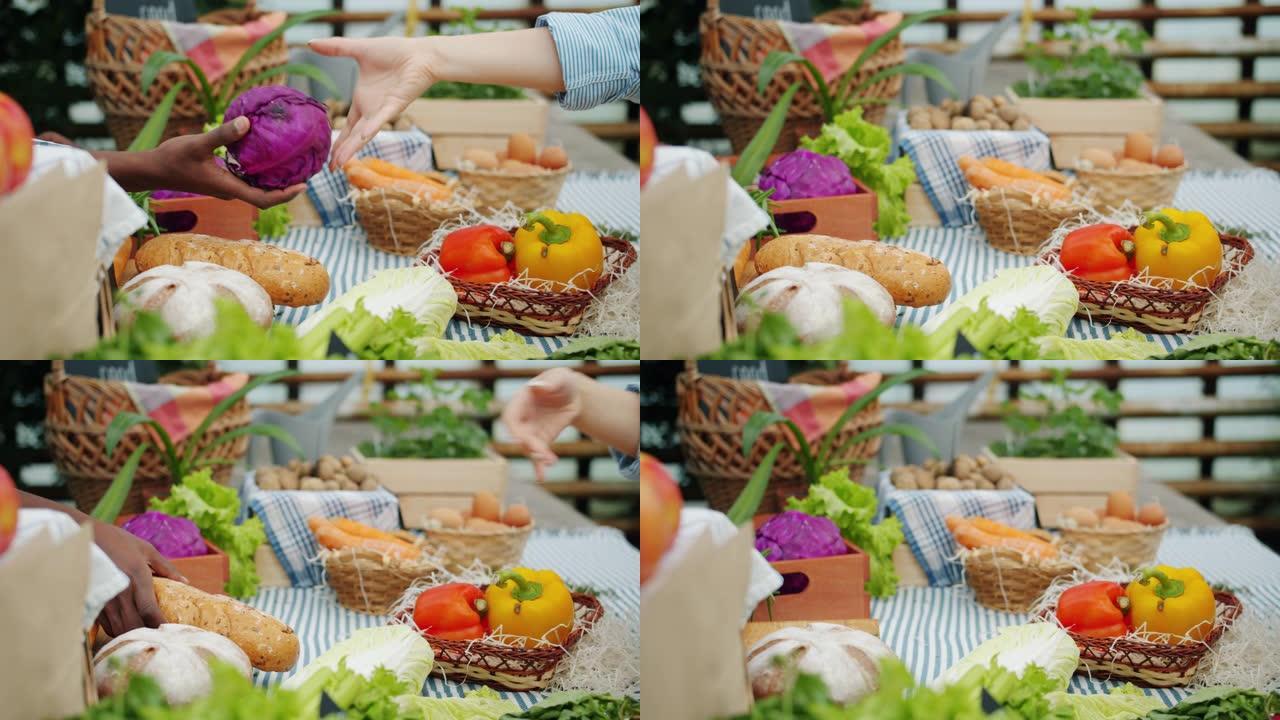 在农场市场上从摊位上拿白菜和面包的手的特写镜头