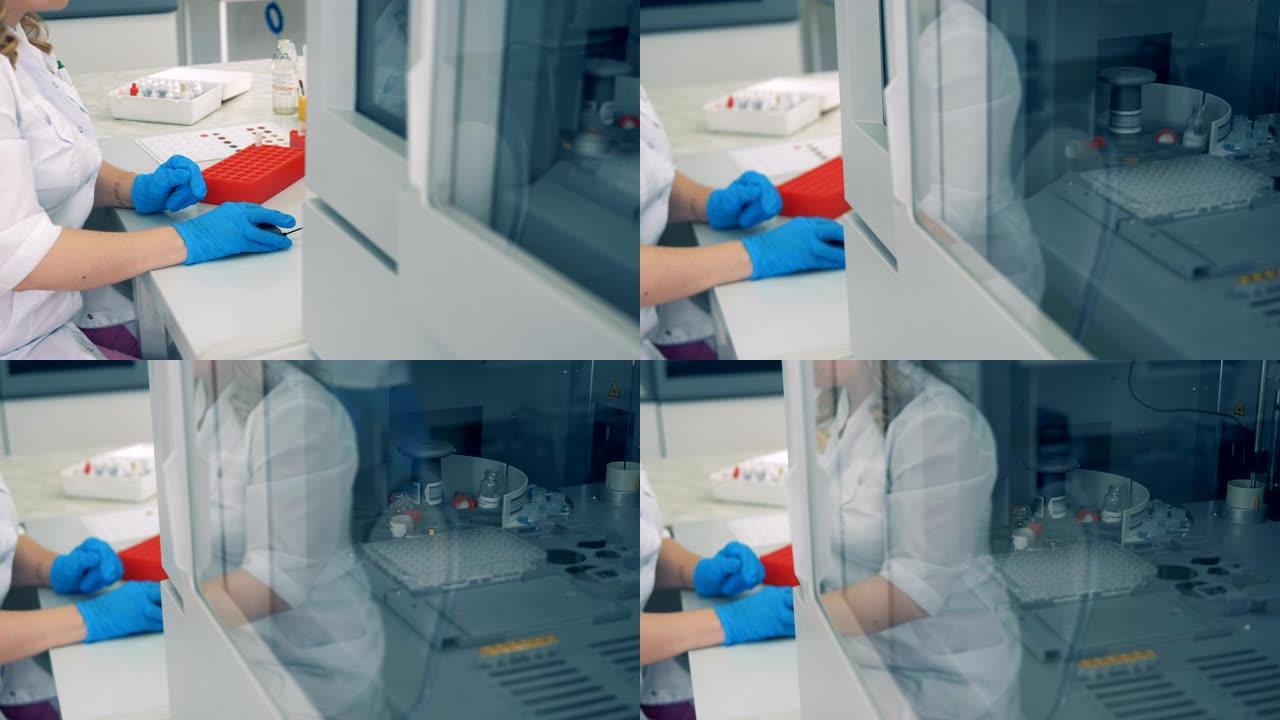 当实验室工作人员在电脑前工作时，带血的管子在离心机里被检查。