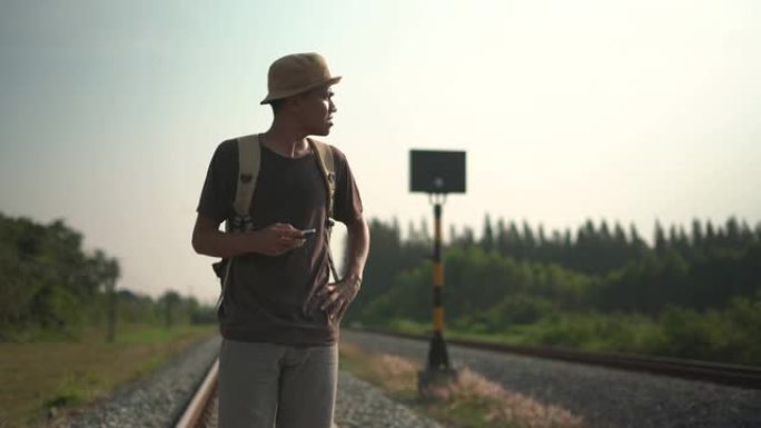 一名年轻男性游客使用手机在道路上行走