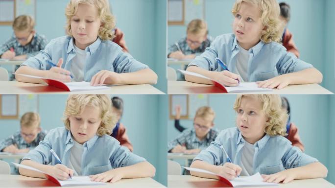 在小学课堂上: 一个聪明可爱的高加索男孩在练习笔记本上写字的肖像。初中教室里有各种聪明的孩子，他们努