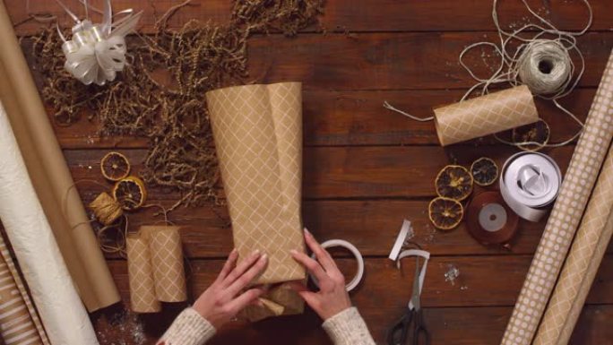 女人的手在木桌上包装圣诞礼物