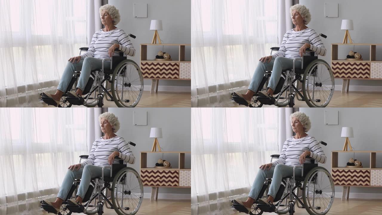 体贴悲伤的老妇人独自坐在轮椅上在家