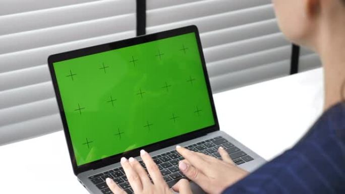 在绿屏笔记本电脑上工作的女商人