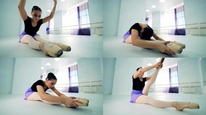 一位芭蕾舞女演员在课堂上伸展双腿，特写镜头。