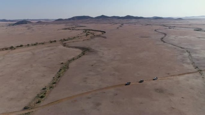 4x4车辆驶过纳米比亚纳米布沙漠的4k高空中平移视图