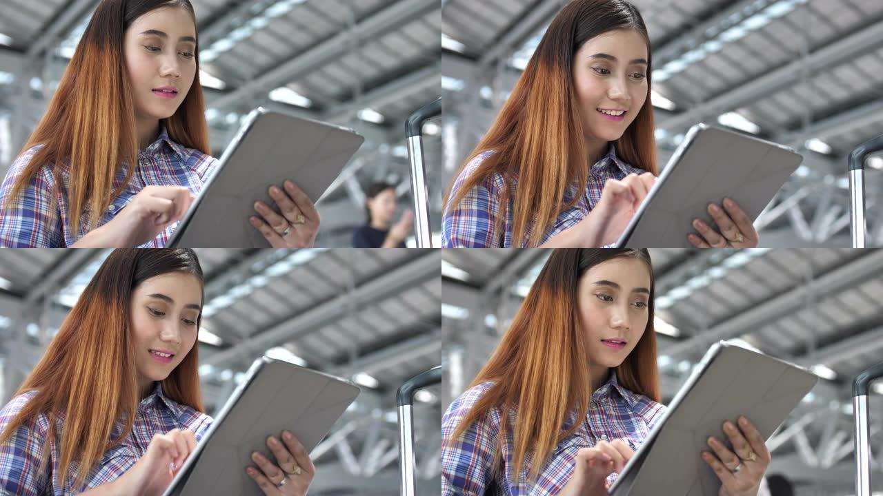 在机场使用数字平板电脑的女人