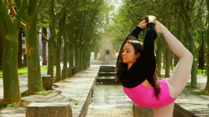 年轻的芭蕾舞女演员在公园4k跳舞时伸腿