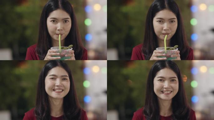 亚洲年轻女子在泰国曼谷旅行，美丽的女性在考山路喝鸡尾酒感到快乐。妇女旅游吃街头食品泰国概念。慢动作镜