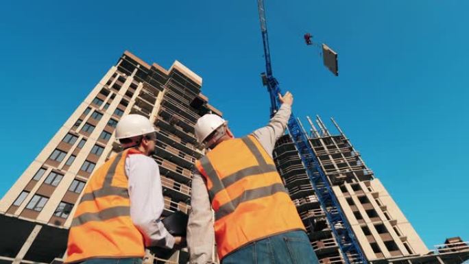 两名工程师正在观察多层建筑的建造