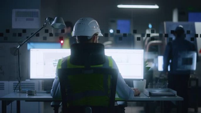 工业工程师解决问题，在个人计算机上工作，两个监视器屏幕显示cad软件与环保电动发动机概念的3D原型。