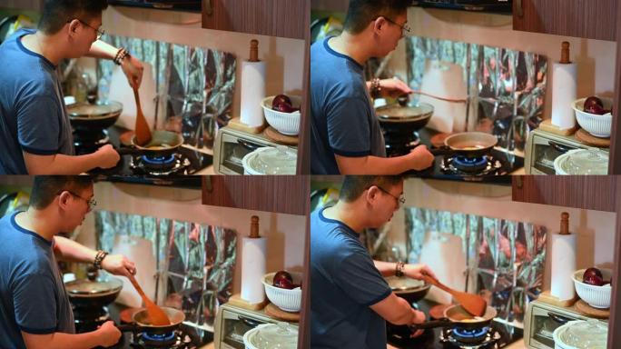一位亚洲华人中年男子在家中厨房做饭，用平底锅煎蛋