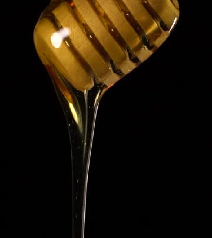 (慢动作和垂直) 从木制蜂蜜北斗七星流出的蜂蜜